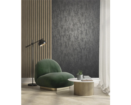 Vardagsrum med mörk mönstrad tapet, fåtölj, bord och golvlampa