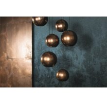 Flera runda hänglampor med metallstruktur hänger från taket.