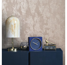 Dekorativ interiör med lampa, klocka och smyckeskrin på en byrå framför en strukturerad tapet