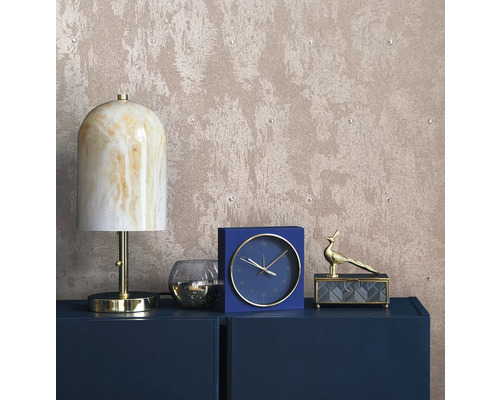 Dekorativ interiör med lampa, klocka och smyckeskrin på en byrå framför en strukturerad tapet