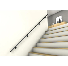 Svart trappräcke på en vägg bredvid en trappa