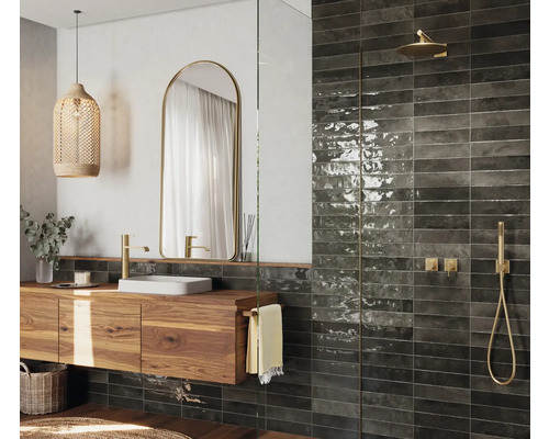 Badrum med tvättställsskåp i trä, spegel, dusch och väggplattor