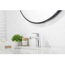 Modernt badrum med tvättställsblandare och rund spegel