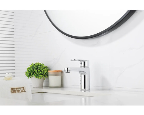 Modernt badrum med tvättställsblandare och rund spegel