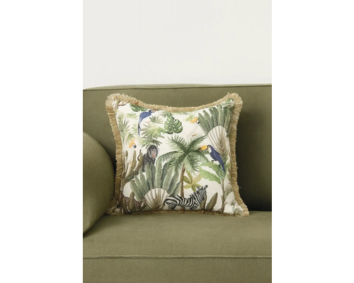 Prydnadskudde med djungelmotiv på en soffa