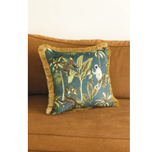 Dekorativ kudde med djungelmotiv och fransar på en soffa