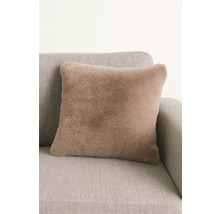 Fyrkantig prydnadskudde med fuskpäls på en soffa