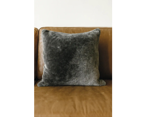 Prydnadskudde i fuskpäls på en soffa