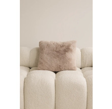 Fyrkantig prydnadskudde med pälsutseende på en soffa.