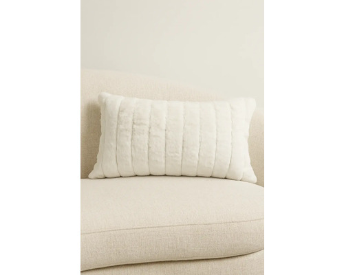 Dekorativ kudde med vertikalt ribbmönster på soffan