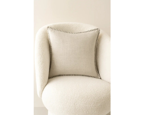 Fyrkantig prydnadskudde med dekorativa sömmar på en fåtölj