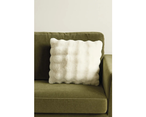 Prydnadskudde med fuskpäls på en soffa