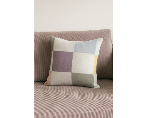 Fyrkantig prydnadskudde med rutmönster på en soffa