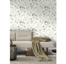 Vardagsrum med blommig tapet, soffa, kudde och sidobord