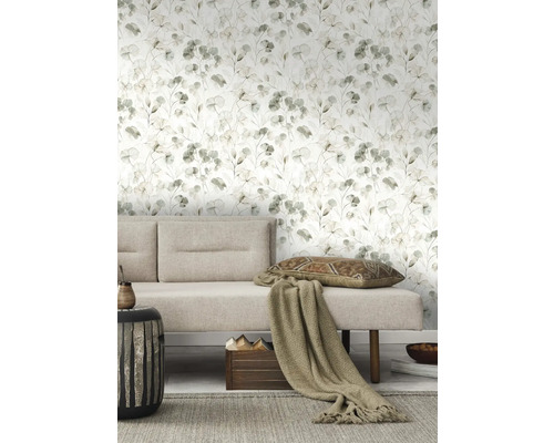 Vardagsrum med blommig tapet, soffa, kudde och sidobord