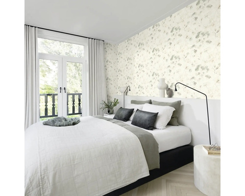 Sovrum med blommig tapet, säng och altandörrar till balkongen.