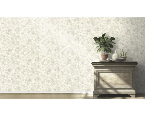 Vägg med blommig tapet och byrå med växter