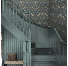 Trapphus med blommig tapet och målad trätrappa