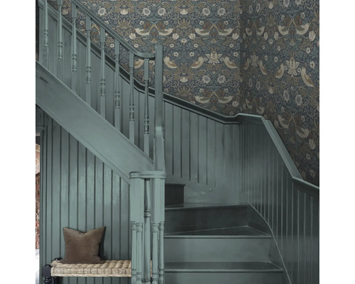 Trapphus med blommig tapet och målad trätrappa