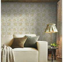 Vardagsrum med mönstrad tapet, soffa och golvlampa