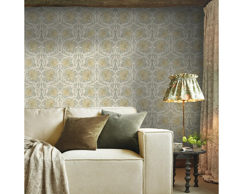 Vardagsrum med mönstrad tapet, soffa och golvlampa