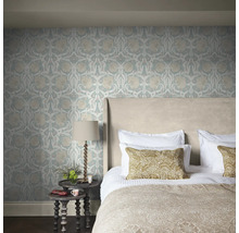 Sovrum med blommönstrad tapet, säng och sängbord