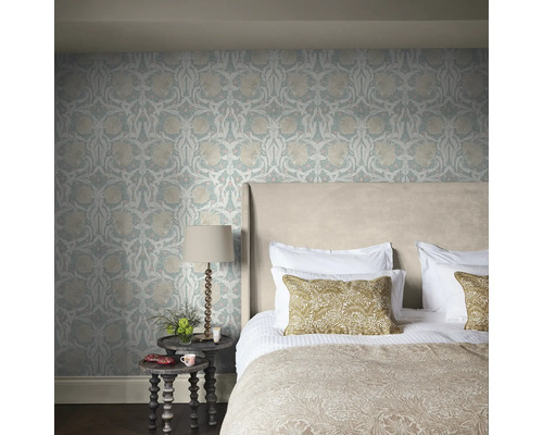 Sovrum med blommönstrad tapet, säng och sängbord