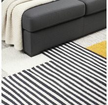 Detaljvy av soffa och randig matta