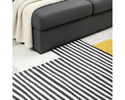 Detaljvy av soffa och randig matta