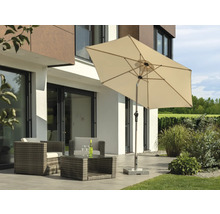 Rektangulärt parasoll med trädgårdsmöbler på en terrass framför ett bostadshus.