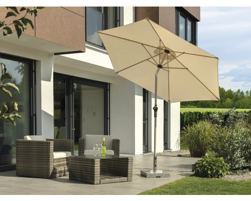 Rektangulärt parasoll med trädgårdsmöbler på en terrass framför ett bostadshus.