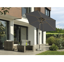 Trädgårdslounge med parasoll på terrass framför modernt hus