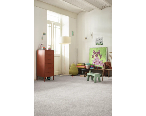 Ljust barnrum med byrå, golvlampa och heltäckningsmatta