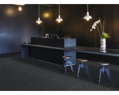 Miljö med mörk heltäckningsmatta, disk, pallar och belysning för en modern kontorsmiljö.
