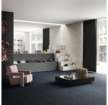 Försäljningsrum med skor på trappsteg och podier, fåtölj och heltäckningsmatta