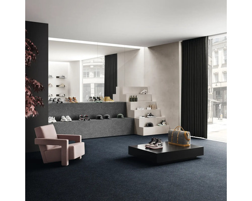 Försäljningsrum med skor på trappsteg och podier, fåtölj och heltäckningsmatta