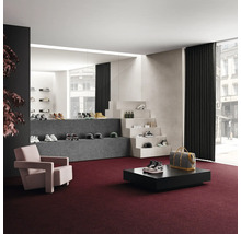 Interiör med heltäckningsmatta, fåtölj, bord och varudisplay av skor och accessoarer