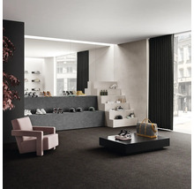 Interiör med heltäckningsmatta, fåtölj och utställningsyta för skor och accessoarer