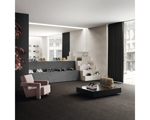 Interiör med heltäckningsmatta, fåtölj och utställningsyta för skor och accessoarer