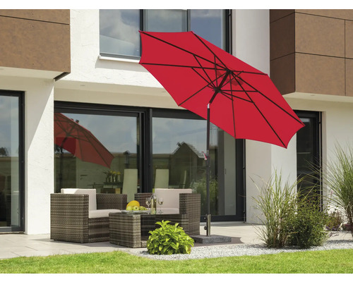 Trädgårdsscen med rött parasoll och loungemöbler