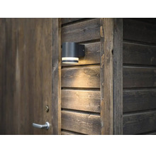 Utomhusvägglampa bredvid en trädörr