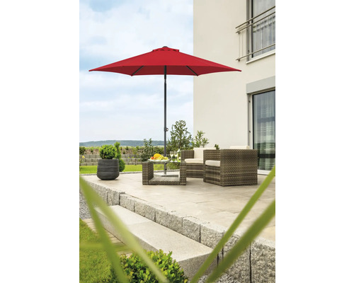 Trädgårdsscen med rött parasoll, rottingmöbler och blomkruka på en terrass
