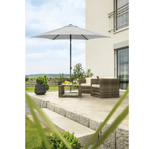 Trädgårdsscen med parasoll, rottingfåtöljer och bord på en terrass