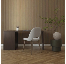 Inredning med skrivbord, stol och krukväxt framför en träpanelvägg