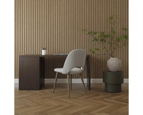 Inredning med skrivbord, stol och krukväxt framför en träpanelvägg