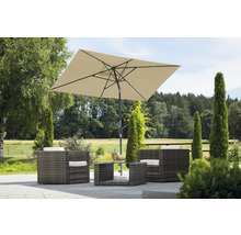 Trädgårdsscen med rottingmöbler, bestående av fåtöljer, bord och ett rektangulärt parasoll