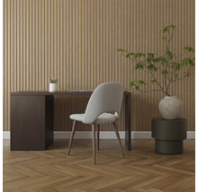 Inredning med skrivbord, stol och dekorativ växt framför en panelvägg