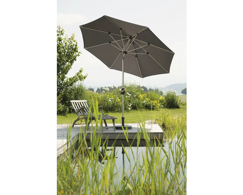 Fyrkantigt parasoll på en träterrass med solstol vid dammen