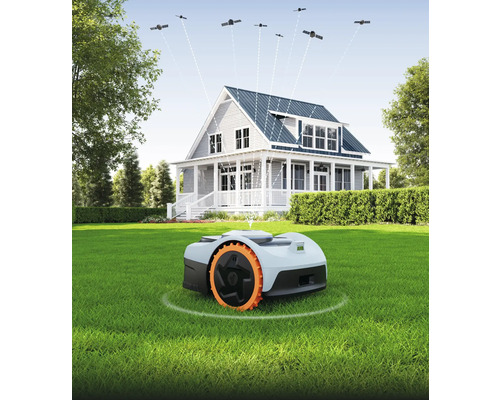 Robotgräsklippare på gräsmatta framför hus med satellitanslutning