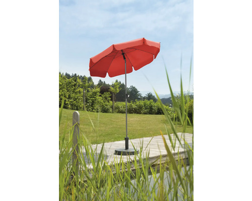 Rött parasoll på en terrass i trädgården